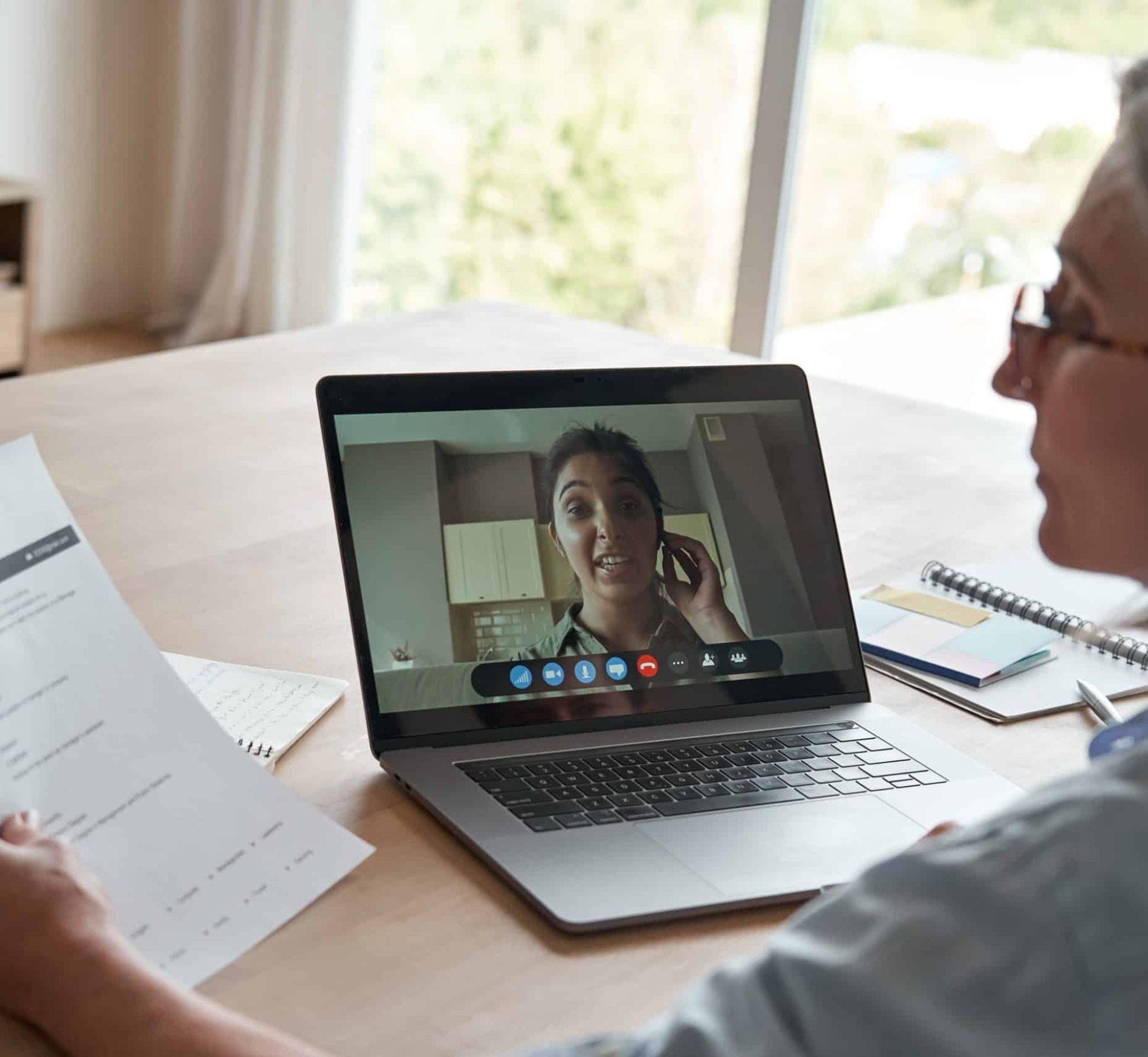 Old female hr employer hr reading cv during online job interview by video call.
